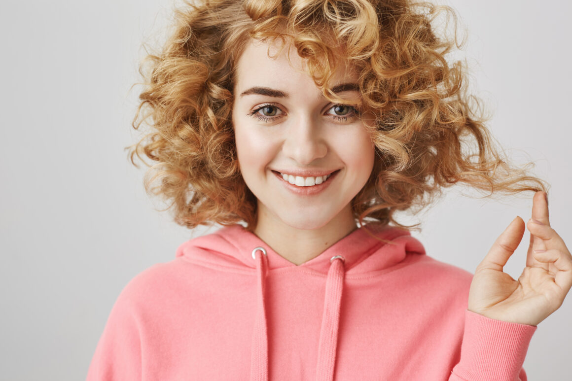 Attractive blond girl with beautiful curls showing her curly hair 