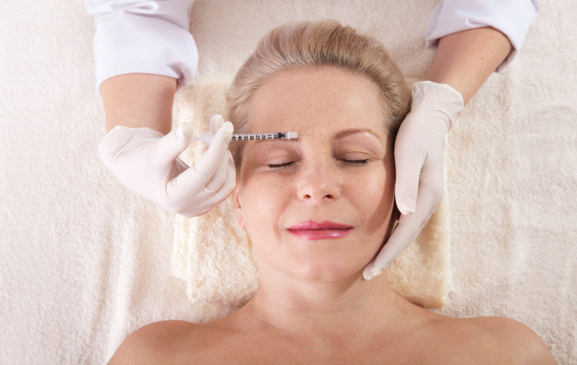 senior woman applying the Hyaluronic Acid Injections on her face by a specialist for anti-aging treatments