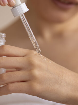 Women applying a skincare serum on her hand skin