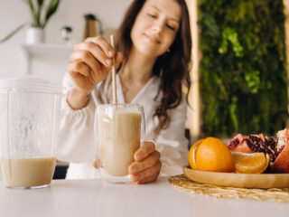 close up of Woman hand about to drink her beauty smoothie