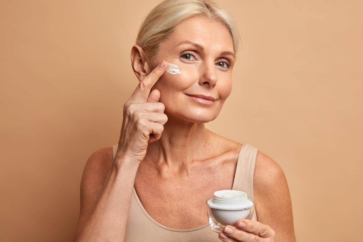 senior beautiful woman applying retinol cream of her face