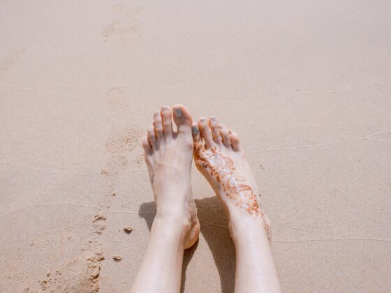 Woman's well-cared-for smooth feet on a soft Focus at a beach sand