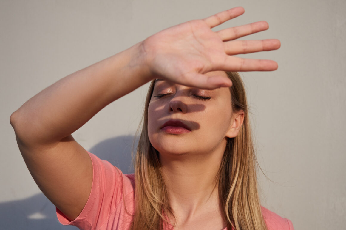 Women protecting her face from sunlight with summer skincare tips