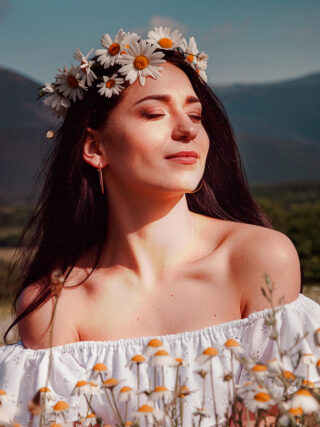 beautiful woman showing her beauty in a daisy field with flowers after embracing Spring Skin Renewal Techniques